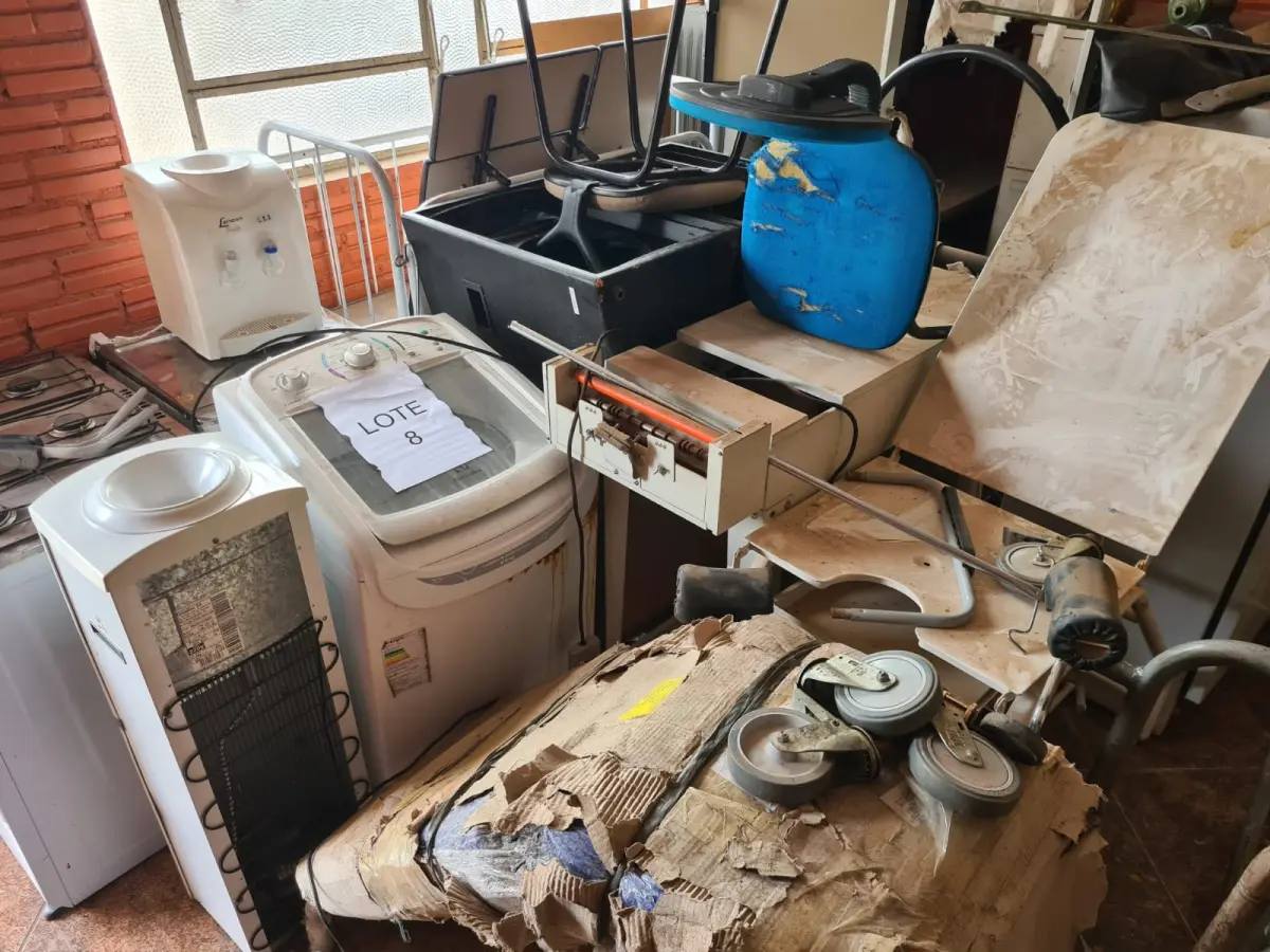 LOTE 008 - Sucata de mesas em madeira, classes e cadeiras escolares, caixas de som, aquecedor a óleo, fogão a gás, máquina de lavar, bebedouro, cama hospitalar, mesas ginecológicas, cadeiras de roda, cadeiras de escritório, máquina para confecção de fraldas e arquivo de aço
