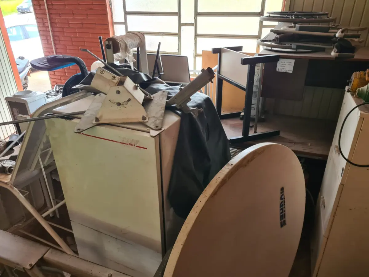LOTE 008 - Sucata de mesas em madeira, classes e cadeiras escolares, caixas de som, aquecedor a óleo, fogão a gás, máquina de lavar, bebedouro, cama hospitalar, mesas ginecológicas, cadeiras de roda, cadeiras de escritório, máquina para confecção de fraldas e arquivo de aço