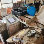 LOTE 008 - Sucata de mesas em madeira, classes e cadeiras escolares, caixas de som, aquecedor a óleo, fogão a gás, máquina de lavar, bebedouro, cama hospitalar, mesas ginecológicas, cadeiras de roda, cadeiras de escritório, máquina para confecção de fraldas e arquivo de aço