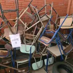 LOTE 008 - Sucata de mesas em madeira, classes e cadeiras escolares, caixas de som, aquecedor a óleo, fogão a gás, máquina de lavar, bebedouro, cama hospitalar, mesas ginecológicas, cadeiras de roda, cadeiras de escritório, máquina para confecção de fraldas e arquivo de aço