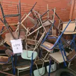 LOTE 008 - Sucata de mesas em madeira, classes e cadeiras escolares, caixas de som, aquecedor a óleo, fogão a gás, máquina de lavar, bebedouro, cama hospitalar, mesas ginecológicas, cadeiras de roda, cadeiras de escritório, máquina para confecção de fraldas e arquivo de aço